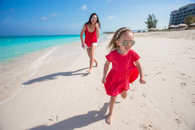 La giovane madre e la bambina si divertono alla spiaggia tropicale