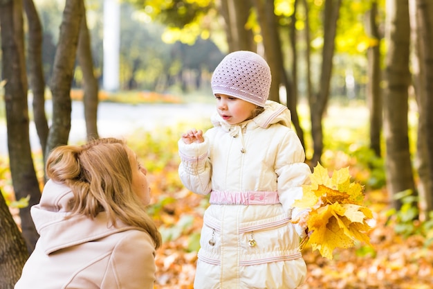 La giovane madre e la sua bambina si divertono in autunno