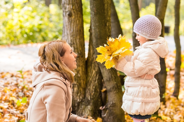 La giovane madre e la sua bambina si divertono in autunno