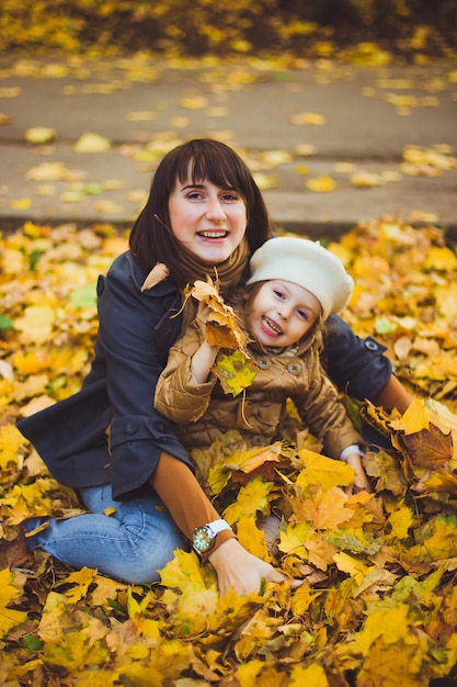 La giovane madre e sua figlia si divertono in autunno