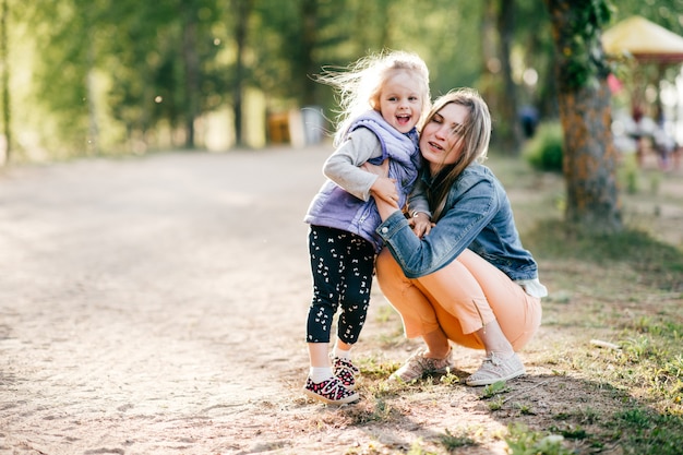 La giovane madre felice si diverte con la sua piccola bella figlia all'aperto