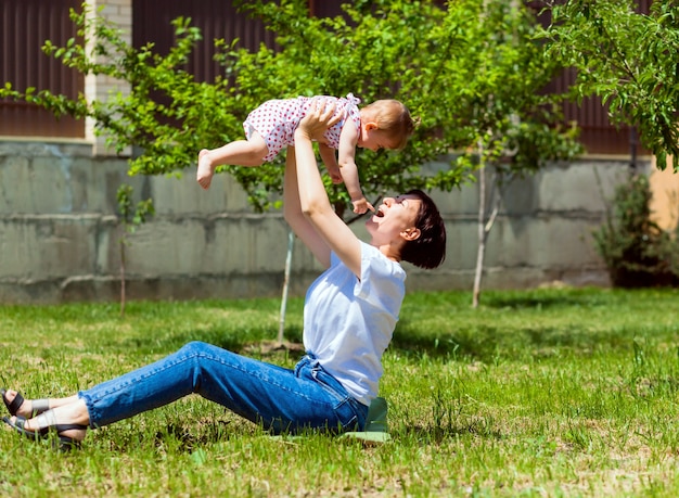 La giovane madre gioca con il suo bambino sull'erba nel parco. Mamma e bambino