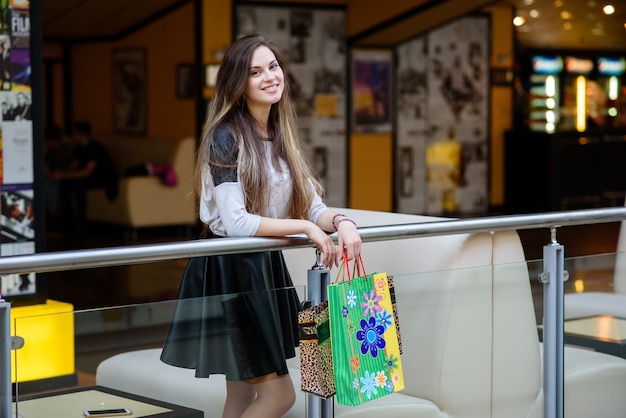 La giovane modella cammina per la città ed è impegnata nello shopping in abito elegante