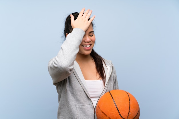 La giovane ragazza asiatica che gioca a pallacanestro sopra la parete isolata ha realizzato qualcosa e intendendo la soluzione