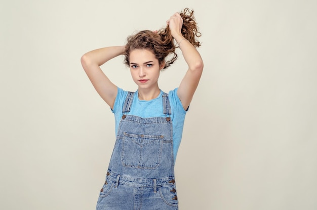 La giovane ragazza attraente ha alzato i capelli con le mani in su Bel sorriso Den