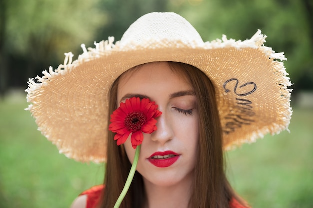 La giovane ragazza attraente tiene un mazzo di fiori di campo estivi.