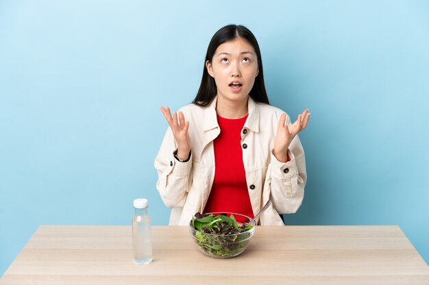 La giovane ragazza cinese che mangia un'insalata ha sottolineato sopraffatto