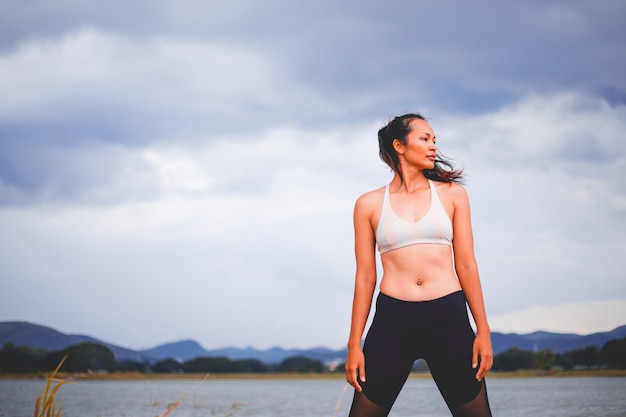 La giovane ragazza di sport fa l&#39;yoga nel parco, donna asiatica di bellezza