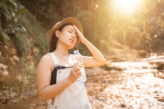 La giovane ragazza sportiva beve l'acqua da una bottiglia La donna sta correndo