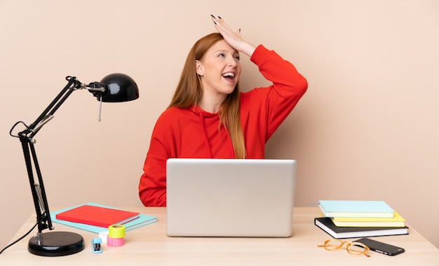 La giovane studentessa in un posto di lavoro con un computer portatile ha realizzato qualcosa e intendendo la soluzione