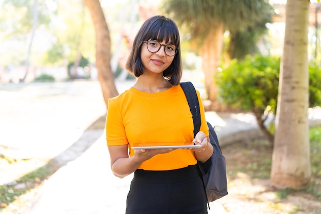 La giovane studentessa vince un parco con in mano un tablet