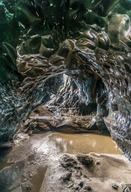 La grotta di ghiaccio situata sotto il ghiacciaio tra le montagne di ghiaccio in Islanda è un punto di riferimento affascinante