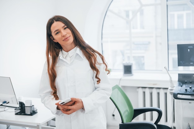 La lavoratrice professionale della clinica in camice bianco è al chiuso nell'armadietto