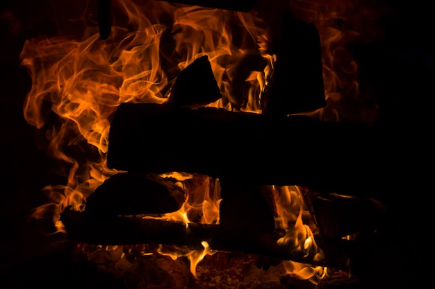 La legna da ardere brucia con un fuoco arancione nel camino Riscaldamento della casa senza elettricità