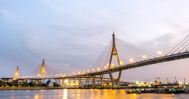 La lettera tailandese del ponte enorme significa il nome 'Bhumihol' attraversa il fiume Chaophraya nel cielo al crepuscolo serale di Bangkok