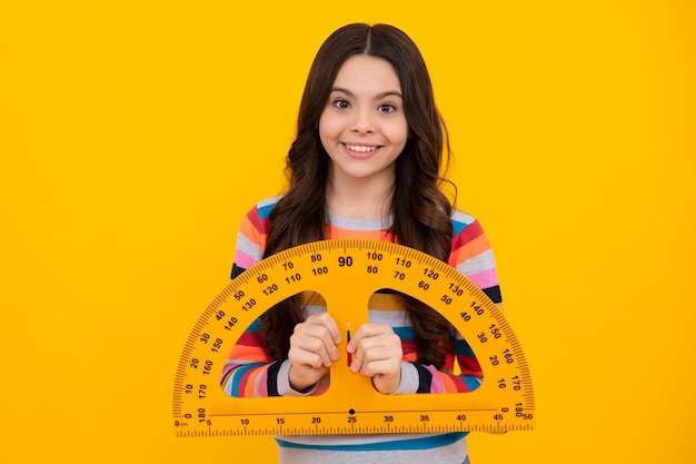 La lezione di matematica o geometria di studio della ragazza della scuola dell'adolescente misura la dimensione Righello matematico per la misurazione Studentessa felice, positiva e sorridente