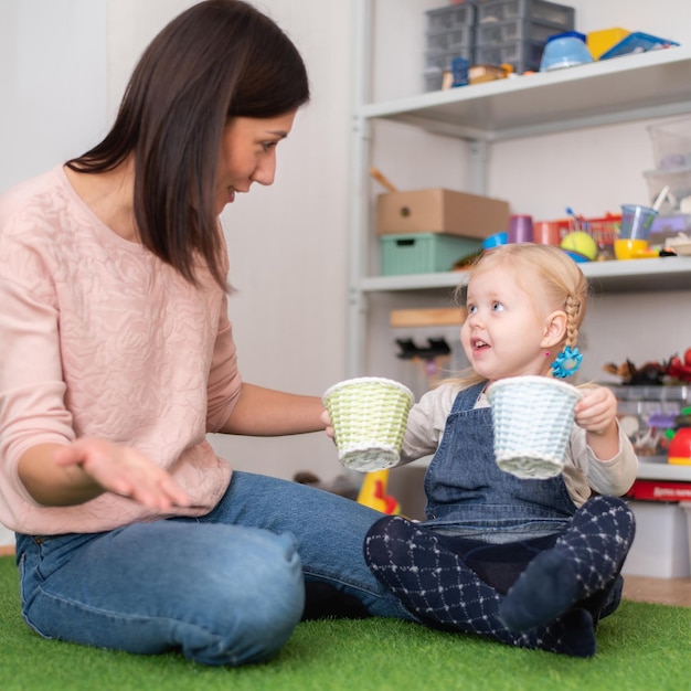 La logopedista aiuta la bambina a correggere il suo discorso nel suo ufficio