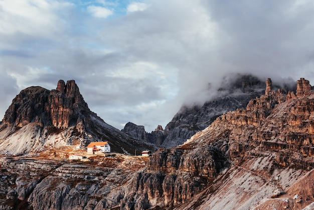 La luce del sole attraversa a malapena le spesse nuvole. Edifici turistici in attesa di chi vuole attraversa queste incredibili montagne dolomitiche.