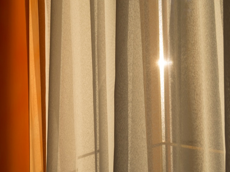 La luce del sole del mattino che passa attraverso la spessa tenda della finestra