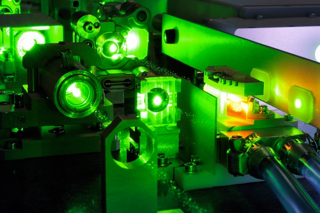 La luce laser verde brillante che entra all'interno complica il sistema scientifico con i tubi di raffreddamento all'interno