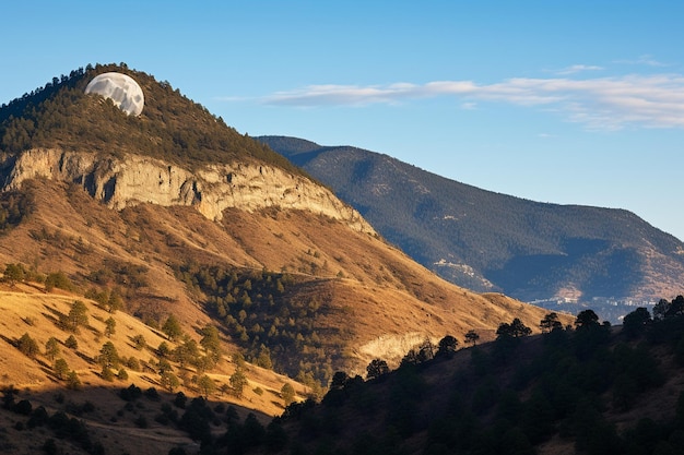 La luna gibbosa che sorge sulla silhouette di una montagna