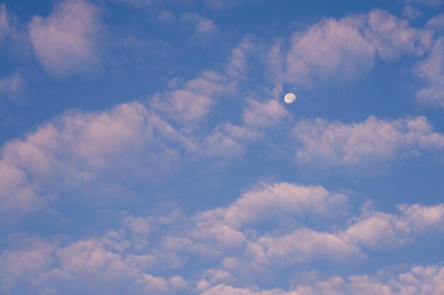 La luna nel cielo azzurro tra le nuvole è come uno sfondo