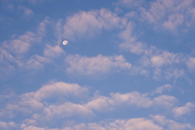 La luna nel cielo azzurro tra le nuvole è come uno sfondo