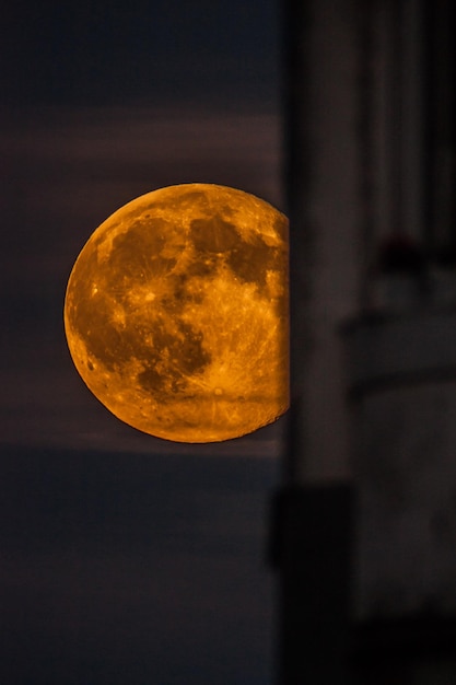 La luna nel cielo notturno si nasconde dietro la casa