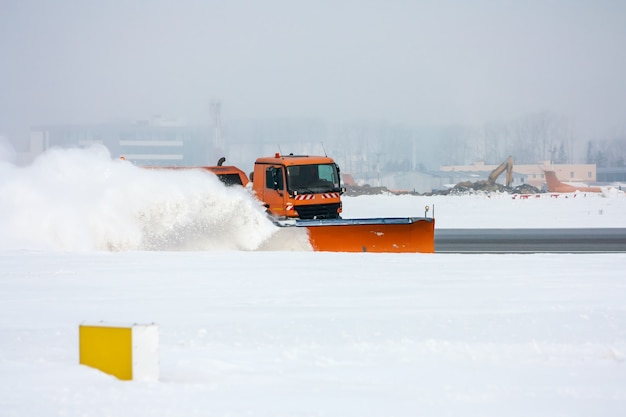 La macchina sgombraneve pulisce la pista dell'aeroporto