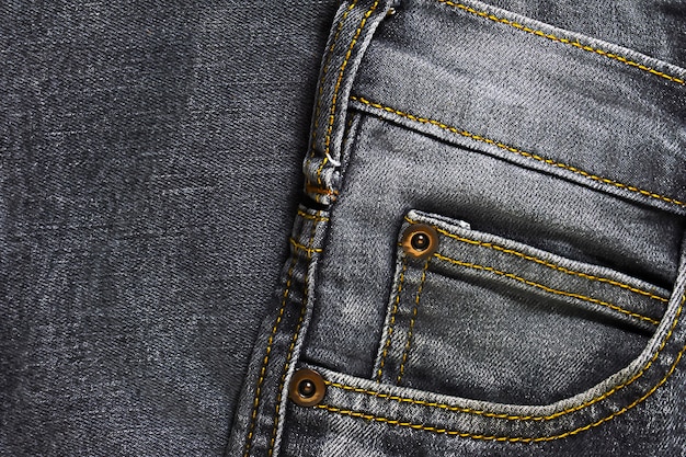 La macro del fondo e pantaloni grigi vicini di fine mostrano molti dettagli sul botton arrugginitamente dei pantaloni