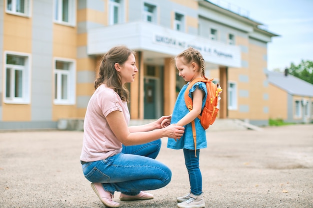 La madre accompagna la figlia a scuola tenendosi per mano