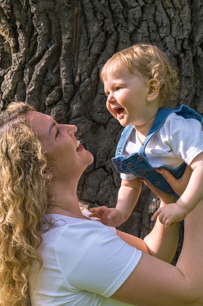 la madre alleva allegramente un bambino piccolo Il ragazzo ride allegramente Il bambino ha un anno