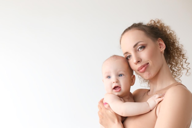 La madre amorevole abbraccia e bacia un bambino che lo tiene tra le braccia in studio