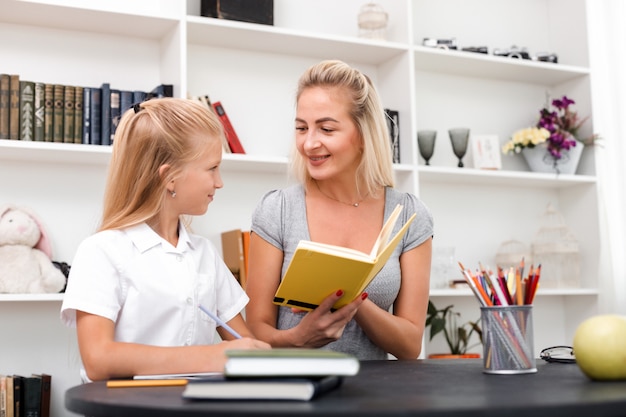 La madre amorevole mostra alla sua piccola figlia un libro