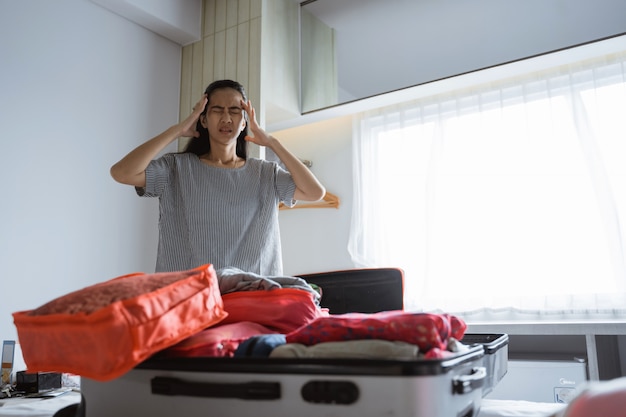 La madre asiatica ha mal di testa quando prepara vestiti e borse