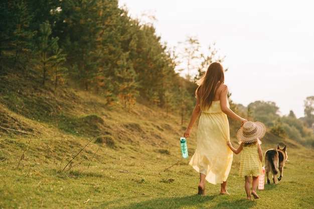 la madre cammina con la sua piccola figlia e il loro cane