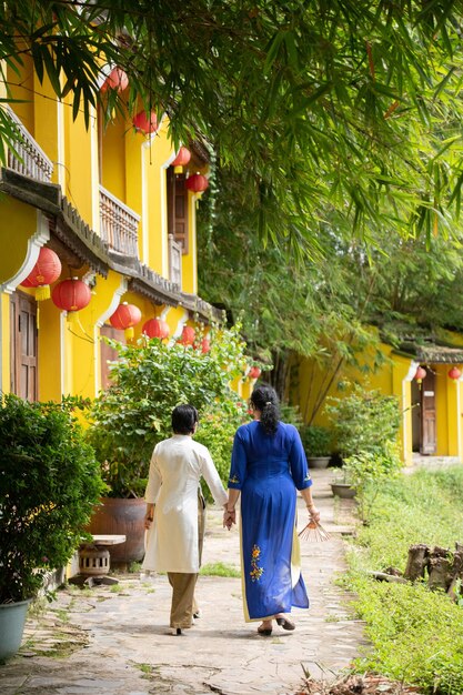 La madre caucasica e la figlia asiatica ad Ao Dai visitano una città vecchia