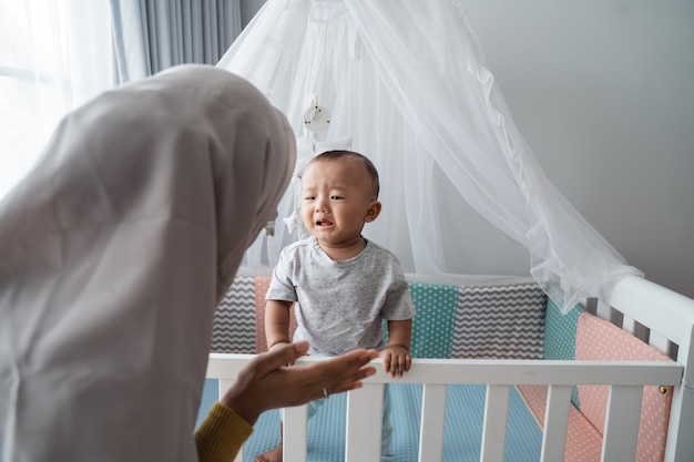 La madre cerca di confortare il suo bambino piangente al presepe