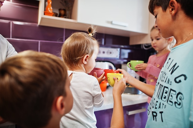 La madre con i bambini beve la composta in cucina, momenti felici per i bambini.