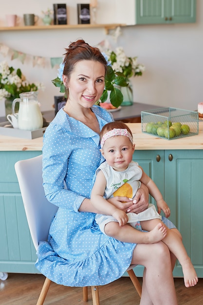 La madre della famiglia e la figlia del bambino nella mattina fanno colazione in cucina