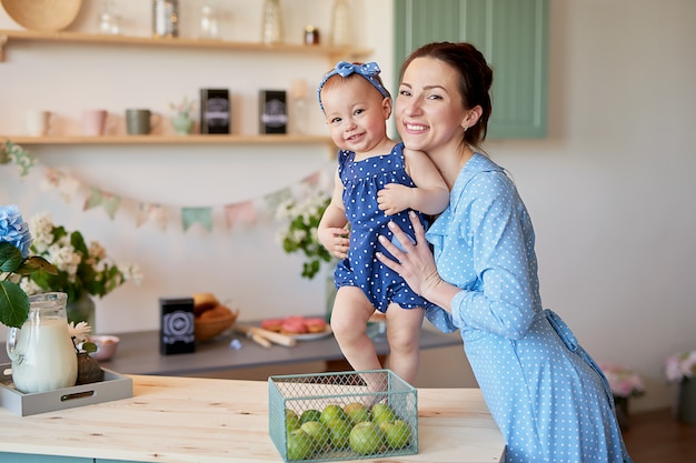 La madre della famiglia e la figlia del bambino nella mattina fanno colazione in cucina