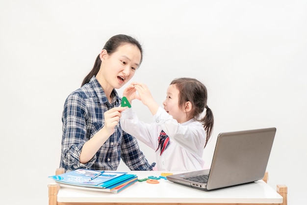 La madre e la bambina stanno imparando le lettere inglesi