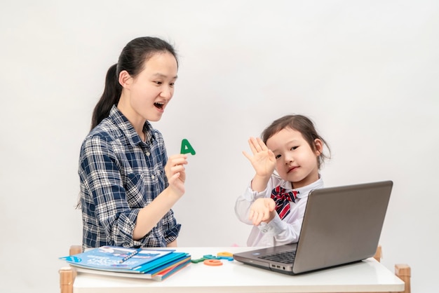 La madre e la bambina stanno imparando le lettere inglesi