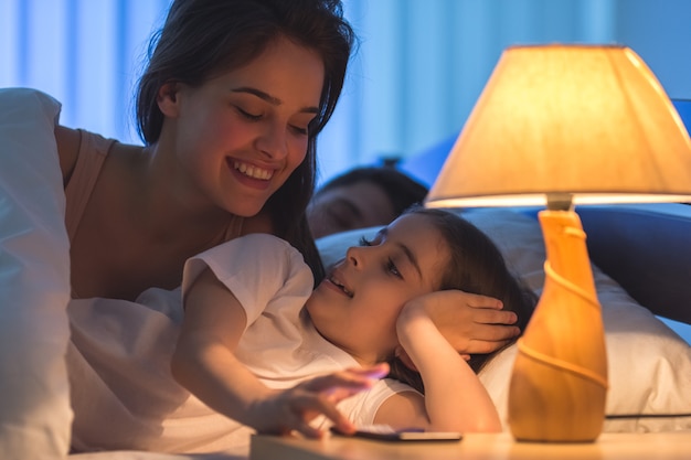 La madre e la figlia telefonano a letto. notte