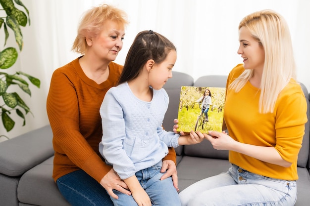 la madre e la nonna della bambina tengono la tela della foto all'interno.