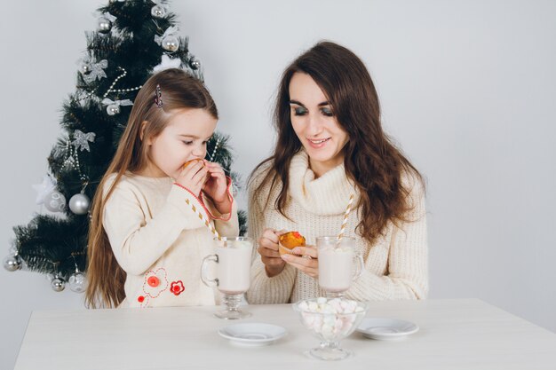 La madre e la piccola figlia mangiano i deliziosi cupcakes