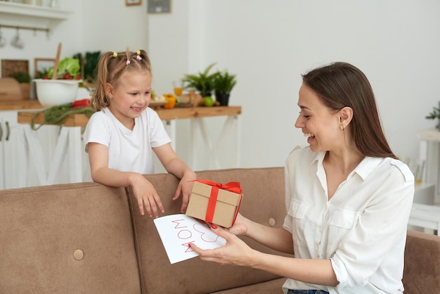 La madre felice accetta un regalo dalla sua piccola figlia Congratulazioni per il compleanno della festa della mamma