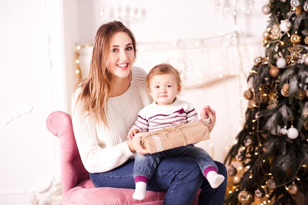 La madre felice apre il regalo di Natale con la bambina