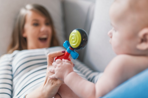 La madre gioca con il bambino con il sonaglio.