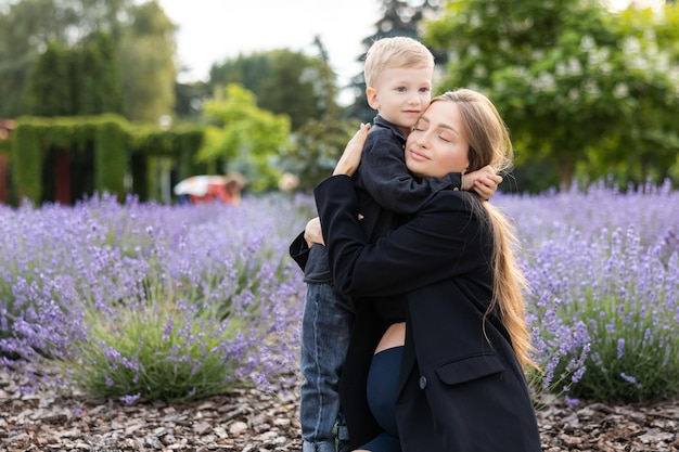 La madre incinta e il suo figlioletto trascorrono del tempo insieme nel parco abbracciandosi e sorridendo